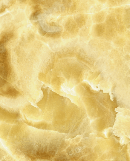 Honey Onyx Marble texture close-up with golden translucent pattern for luxury interior applications in India